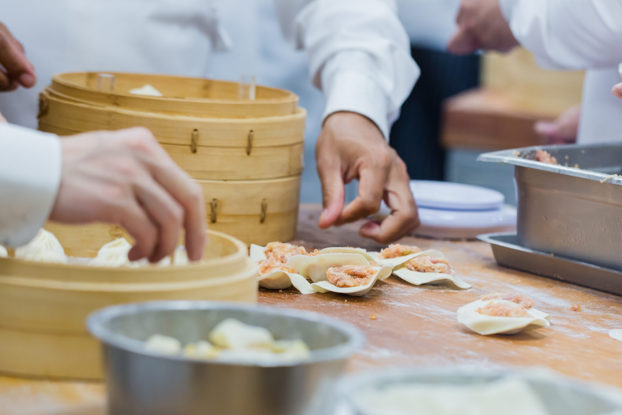 Manufacture of dim sum by Chinese chefs in restaurant.